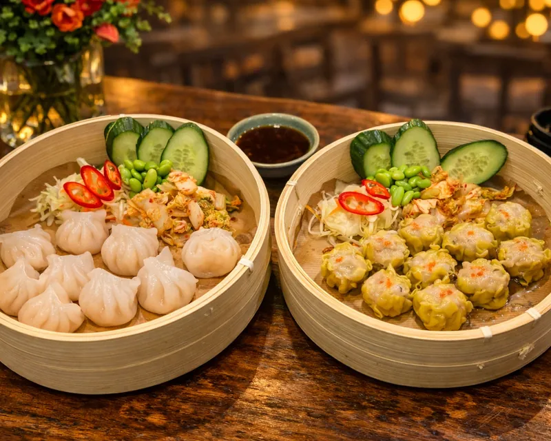 Två bamburångkorgar med ångkokta dumplings på ett träbord i restaurangen